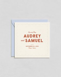 an orange and white save the date card on top of a blue envelope with red lettering