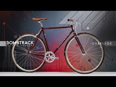 a red bike is shown in front of a colorful background with the words bombtrack on it