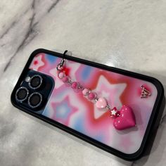 an iphone case with some charms attached to it