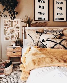 a bedroom with two pictures on the wall above the bed, and a yellow blanket