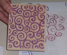 a person is holding a wooden stamp with swirl designs on it, next to other stamps