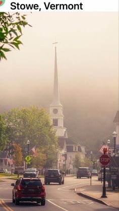 cars driving down the road in front of a church