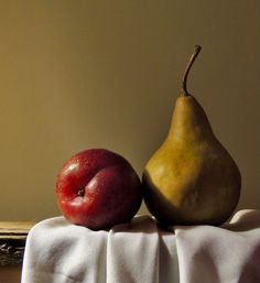 two pears and an apple on a table