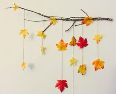 the fall leaves are hanging from the branch and hung on strings with twine cords