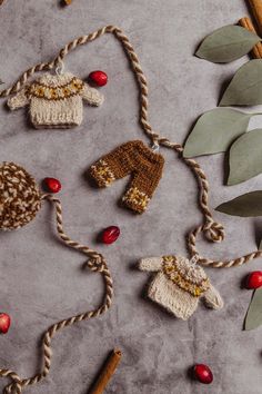 crocheted baby sweaters and mittens are hanging from twine on a table