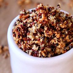 a white bowl filled with granola on top of a table