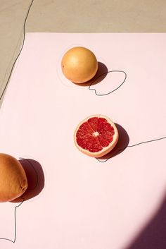 two grapefruits and an orange on a table