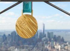 a gold medal hanging from the side of a metal pole in front of a cityscape