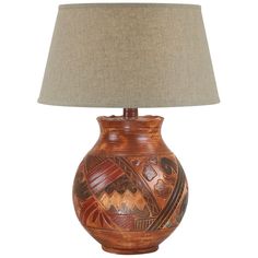 a lamp that is on top of a wooden table with a beige shade over it