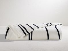 two black and white towels folded on top of each other in front of a white wall