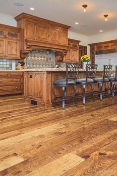 a large kitchen with wooden floors and cabinets