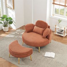 an orange chair and footstool in a living room with a book on the floor