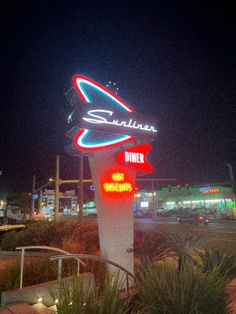 the sign is lit up at night for diners