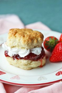 a scone with cream and strawberries on a plate