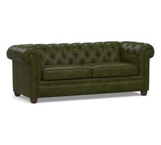 a green leather couch with buttons on the armrests and wood legs, sitting against a white background