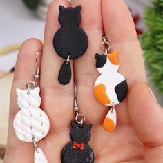 three keychains with different designs on them in the shape of cats and dogs