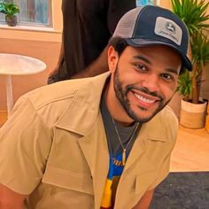 a man wearing a hat and smiling for the camera