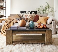 a living room filled with lots of furniture and decor on top of a white rug