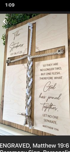 a wooden cross with the names of jesus on it and some rope attached to it