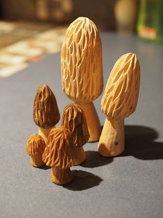 three wooden mushrooms sitting on top of a table