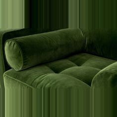 a green couch sitting on top of a wooden floor