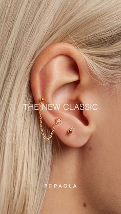 a woman with blonde hair wearing a gold chain ear cuff and an earring in the shape of a cross