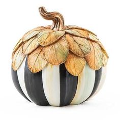 a black and white striped pumpkin with gold leaves