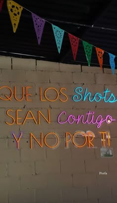 a neon sign that reads que los shots, san contigo y'por it