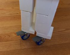 a pair of blue dolly wheels on top of a wooden floor next to a white door