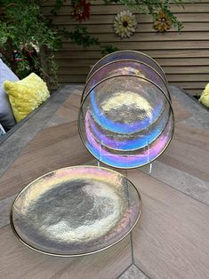 three plates sitting on top of a wooden table next to a yellow and white pillow