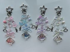 several charms are hanging from the side of a white surface, with stars on them