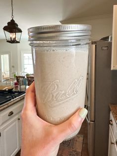 a person holding a mason jar in their hand