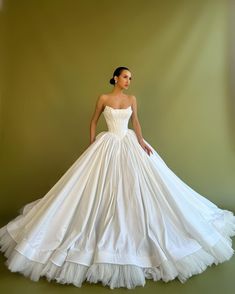 a woman in a white wedding dress posing for the camera