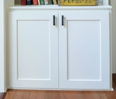 a book shelf with books on top of it and a clock in the corner next to it