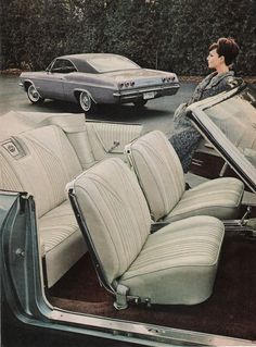 an old photo of a woman sitting in the driver's seat of a car