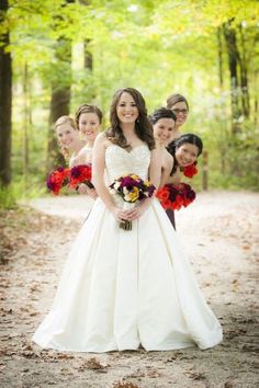 a bride and her bridals posing for a photo in the woods with their bouquets