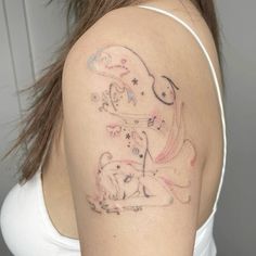 a woman with a tattoo on her shoulder has a cat and dog design on it