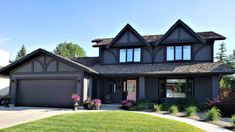 a large house with two car garages and lots of grass in front of it