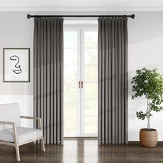 a living room with white brick walls and black drapes on the windowsills