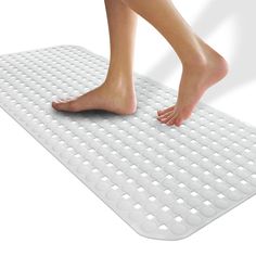 a woman's bare feet are standing on a white mat with holes in it