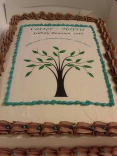 a cake decorated with a family tree on it's side and ribbon around the edges