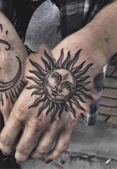 two hands with sun and moon tattoos on their palms, one holding the other's hand