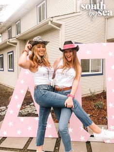 two young women posing in front of a large letter with stars on the letters,