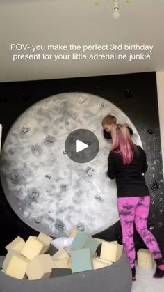 a woman standing in front of a large moon with blocks of cheese on it's side