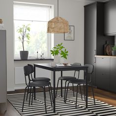 a black and white striped rug in a dining room with two chairs at the table