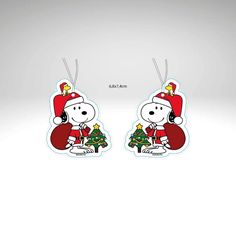 snoopy christmas earring with santa hat and tree on the bottom, in white background