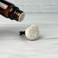 a bottle stopper with a flower design on the front and bottom is shown next to an empty wine bottle