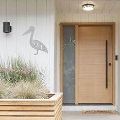 two planters are in front of a door with a pelican on it