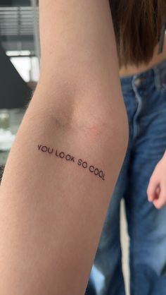 a woman's arm with the words you look so cool tattooed on her left arm