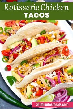 three chicken tacos on a plate with onions, peppers and avocado